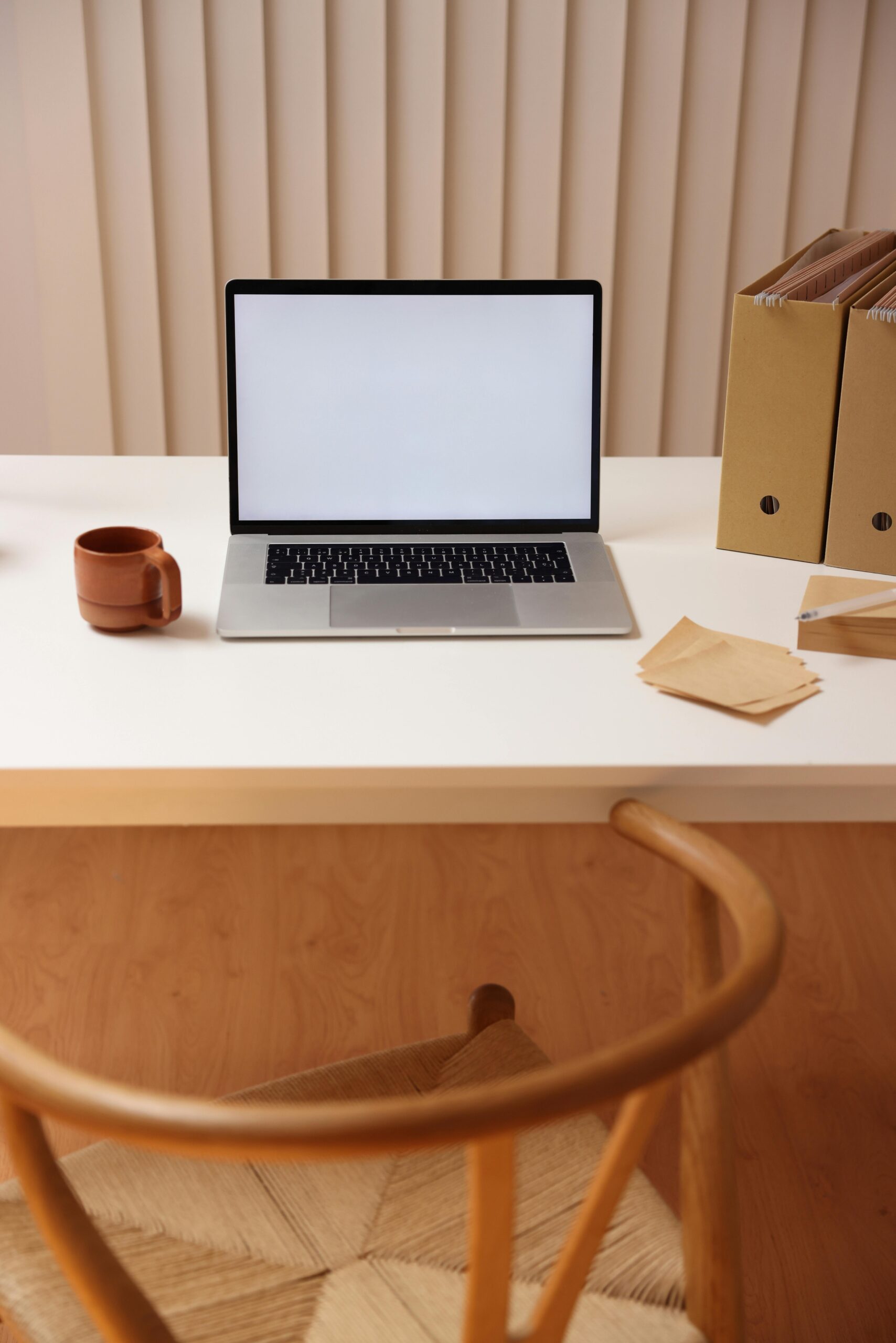 Simple workspace setup with open laptop, coffee cup, and folders. Ideal for remote work inspiration.